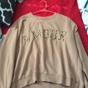 A nude colored shirt with the word “AMOUR”